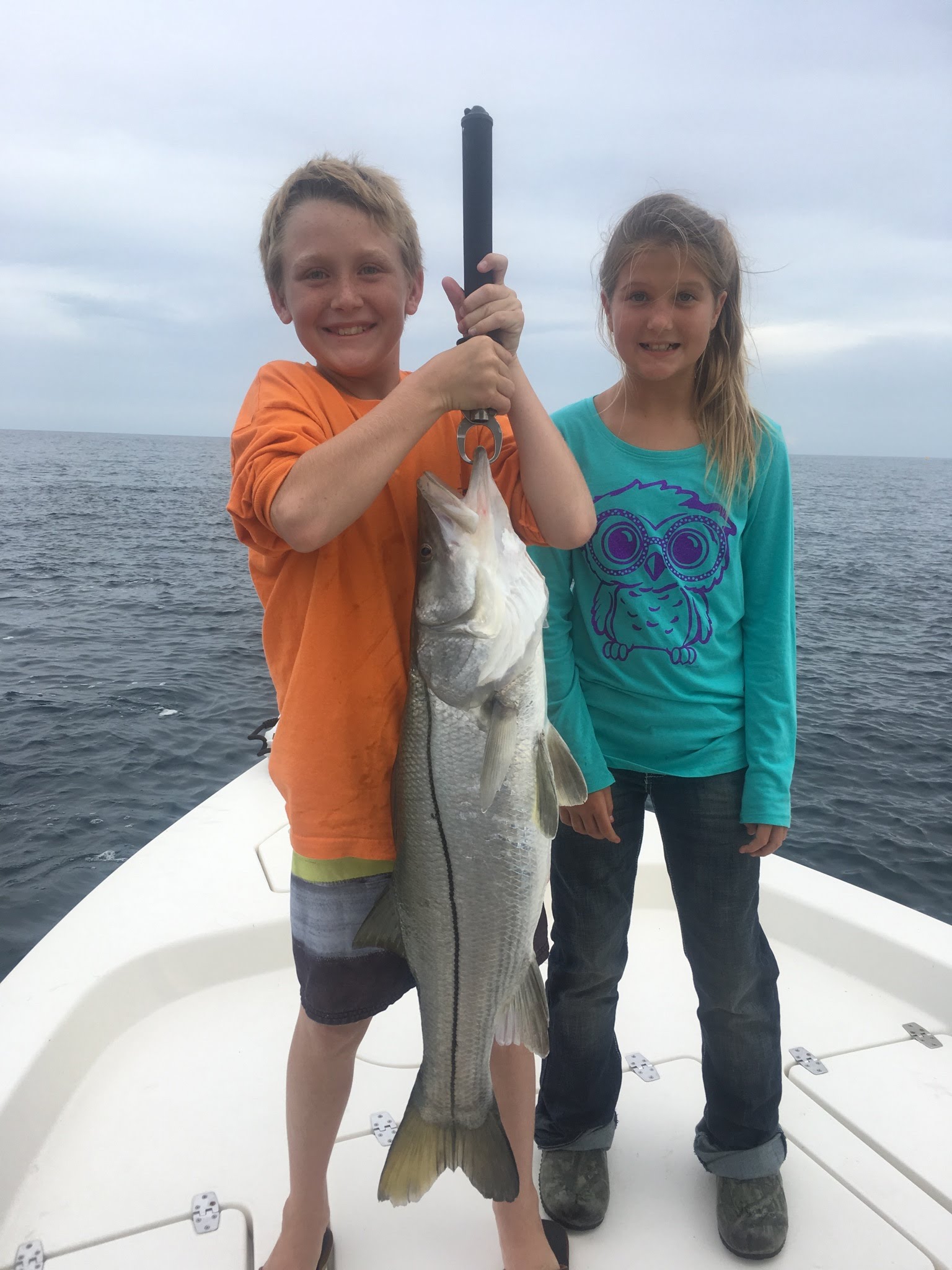kids holding large fish
